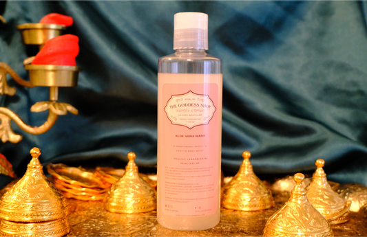 a clear bottle of aloe vera minty feminine wash/ yoni wash. The liquid is pale pink/white